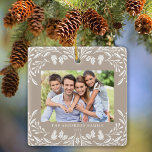 2 foto's Familie Winter Groen Tan Kerstmis Keramisch Ornament<br><div class="desc">Dit lichtbruine kerstornament toont een sierlijke witte wintergroene afbeelding die de horizontale foto lijst. Het ontwerp biedt ruimte voor 2 van uw favoriete afbeeldingen,  een aan de voorkant en een andere aan de achterkant. Personaliseer dit mooie aandenken ornament met uw familienaam en het jaar.</div>