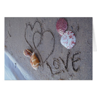 2 Harten in zand met schelpen met liefde