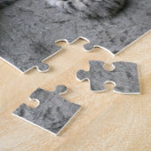 4 maanden oude sneeuwluipaardwelp gedrapeerd over legpuzzel (Zijkant)