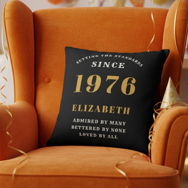 50th Birthday Gift Personalized 1976 Black Gold Kussen (Personalized 50th birthday pillow on a vibrant orange velvet wingback chair)