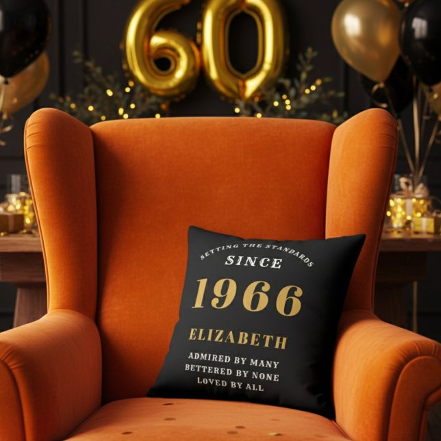 60th Birthday Gift Personalized 1966 Black Gold Kussen (A personalized black pillow on a vibrant orange velvet wingback armchair )