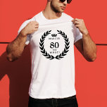 80 Dus wat een grappige Laurel Krans Kroon 80e ver T-shirt<br><div class="desc">80 So What Funny Laurel Wreath Crown 80th Birthday T-shirt. Een grappig citaat Ik ben 80 dus wat in moderne vetgedrukte lettertypen en zwarte kleur. Het ontwerp heeft een lauwerkrans rond de woorden en een kroon boven de aangepaste naam. Voeg jouw namen toe. Een perfect cadeau voor een man met...</div>