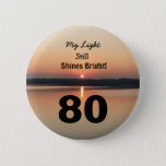 80th Birthday Sunset My Light Still Shines Bright Ronde Button 5,7 Cm<br><div class="desc">Give a happy 80th birthday button to express his "My Light Still Shines Bright" gevoel. A bold design with a black and gold sunrise on a peaceful lake sends a message of stimuland love. An endearing verse for an inspiring birthday celebration.</div>
