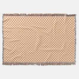 A checkered pattern throw blanket with orange  deken