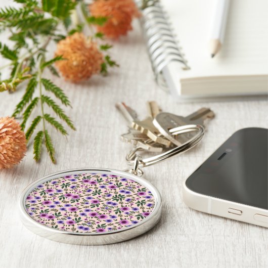A round keychain features a detailed floral  (Zijkant)