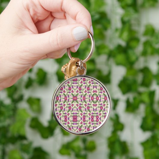 A round keychain features a detailed floral  (Hand)