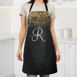 Aangepast goudglitter zwart monogram schort<br><div class="desc">Pas dit trendy elegante schort-ontwerp met  gouden mousserende glitter eenvoudig aan op een zwarte geborstelde metalen achtergrond.</div>