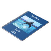 Aangepaste dolfijnen die in de oceaan spelen en tr notitieboek (Linkerzijde)