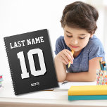 Aangepaste zwarte achternaam Sports Jersey Number Notitieboek<br><div class="desc">De naam,  het aantal en de dalingsschaduw zijn klantgericht zodat kunt u een sportief uitziend maar nuttig notitieboek uniek maken en aan uw favoriete sportteamkleuren of kamerdecor aanpassen. Zwarte achtergrond.</div>