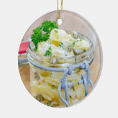 Aardappelsalade in een pot op hout keramisch ornament (Links)