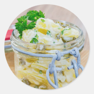 Aardappelsalade in een pot op hout ronde sticker
