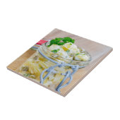 Aardappelsalade in een pot op hout tegeltje (Zijkant)