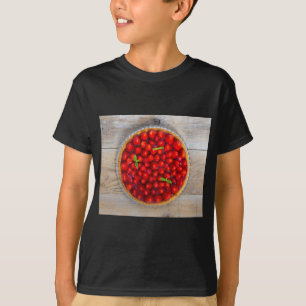 Aardbeiencake met nertsbladeren op een bijtend hou t-shirt