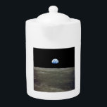 Aarde van maan in zwarte ruimte: aardopgang theepot<br><div class="desc">Vanuit de desolate maanvlakten, hangt de aarde als een fragiel ornament in de afgrond. Het schril contrast tussen de steriele grijswaarden van het maanlandschap en het bruisende blauwe marmer van de Aarde ontbrandt een knal van vreemdheid in de maan. Talloze nachten had het gezien dat de aarde de hemel domineerde,...</div>