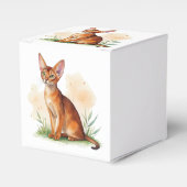 Abessijnse kat omringd door zachte kleuren en groe bedankdoosjes (Voorkant Zijde)