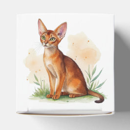 Abessijnse kat omringd door zachte kleuren en groe bedankdoosjes