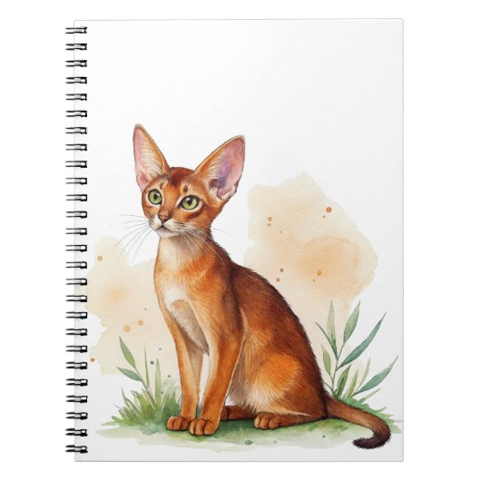 Abessijnse kat omringd door zachte kleuren en groe notitieboek (Voorkant)