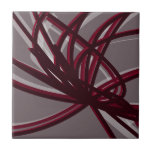 Abstract lint voor grijs en Bourgogne Tegeltje<br><div class="desc">Grijze en onkruidige keramische tegel heeft een artistieke abstracte lintsamenstelling met schoppen van onechte wijn en grijze met witte accenten op een grijze achtergrond.</div>