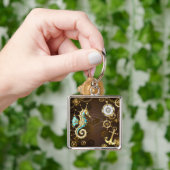 Achtergrond van hout met mechanische zeepaardjes sleutelhanger (Hand)