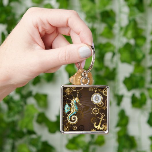 Achtergrond van hout met mechanische zeepaardjes sleutelhanger (Hand)