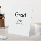 afstudeerder jongen voegt naam toe bevat datumteks reclamebord met voetstuk (Insitu)