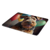 Airedale-hond met cake en ballonnen snijplank (Hoek)