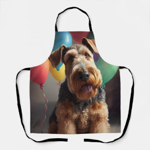 Airedale hond met taart en ballonnen schort