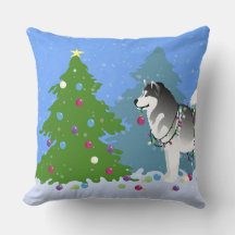 Alaskan Malamute die kerstboom decorreert