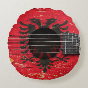 Albanese vlag op de oude akoestische gitaar rond kussen