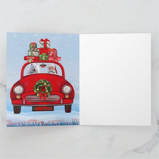 Amerikaanse eskimo-hond in auto's met kerstbedekki kaart (Binnen)