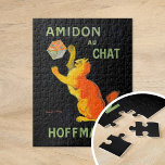 Amidon Au Chat | Leonetto Cappiello Legpuzzel<br><div class="desc">Amidon Au Chat (1903) | Leonetto Cappiello’s vintage advertising poster Amidon Au Chat for Hoffman features a whimsical orange cat playfully interacting with a box of starch, set against a striking black background. The vibrant orange of the cat and the bold typography create a high-contrast design that is both eye-catching...</div>