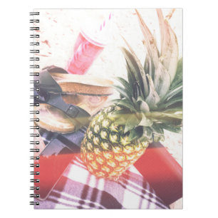 Ananas naast telefoon en luidspreker notitieboek