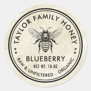 Antieke blauwe bosbessenhoning-etiket met honingbi ronde sticker