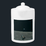 Apollo Maanlander en Aarde boven de maan Theepot<br><div class="desc">De krappe commandomodule diende als tijdelijk onderkomen, en vormde een adembenemend uitzicht. Op de voorgrond bungelde de delicate spinachtige Maanmodule, wachtend op zijn afdaling. Voorbij strekte zich het grimmige, kraterende maanlandschap uit, met dramatische kromming van de horizon. Maar het show stelen was Earth, een levendig blauw marmer opgehangen in de...</div>