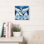 Art Deco Swan en Lilies Sierkussen Vierkante Klok<br><div class="desc">Een witte zwaan spreidt zijn vleugels over art deco lelies op een prachtige blauwe achtergrond.</div>