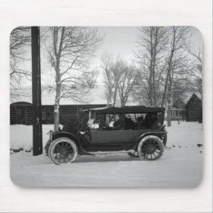 Auto met kerstboom vastgebonden op de kap muismat