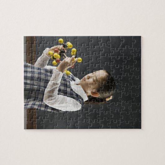 Aziatisch meisje dat naar molecuulmodel kijkt legpuzzel (Horizontaal)