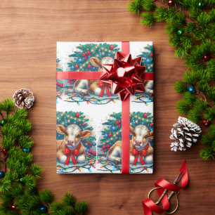 Babykalf ligt bij kerstboom cadeaupapier