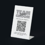 Bachelor QR Code Party Koop Drink Shot Team Groom Reclamebord Met Voetstuk<br><div class="desc">Koop de bruidegom om een drink te zijn! Aangepaste vrijgezellenfeest QR Codetafel sokkel ontwerp voor uw vrijgezellenfeest kenmerken "TEAM GROOM" in vet licht grijs type. Pas de naam van de bruidegom aan in zwart schrift op een heldere witte achtergrond. De titel van het evenement of vrijgezellenfeest wordt hieronder in het...</div>