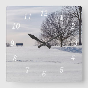 Bank op sneeuw bedekte heuvel muur klok