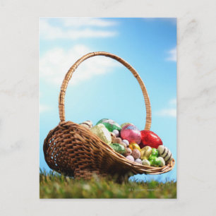 Basket filled with Easter eggs on grass, ground Feestdagenkaart