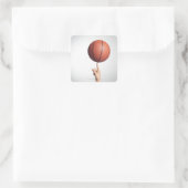 Basketball op wijsvinger, handen dicht bij elkaar vierkante sticker (Tas)