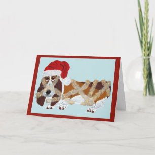 Basset Hound verstrikt in kerstslingers Kaart