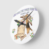 Beagle houdt het koekje van de koekjespot tegen ronde klok (Hoek)