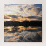 Beauful Winter Sunset over Lake Foto Legpuzzel<br><div class="desc">Deze puzzel bevat een prachtige foto van een winterzonsondergang die tot uiting komt in het water van een meer. De hemel is gevuld met wolken in tinten,  blauw en grijs,  en je ziet een paar bladloze bomen aan de horizon.</div>