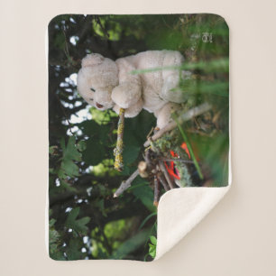 Beertje dat bij kampvuur zit. sherpa deken