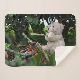 Beertje dat bij kampvuur zit. sherpa deken