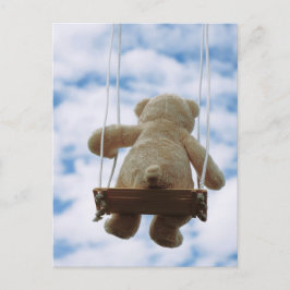 Beertje op schommel met bewolkte blauwe lucht. briefkaart