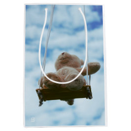 Beertje op schommel met bewolkte blauwe lucht. medium cadeauzakje