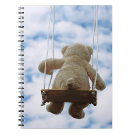 Beertje op schommel met bewolkte blauwe lucht. notitieboek